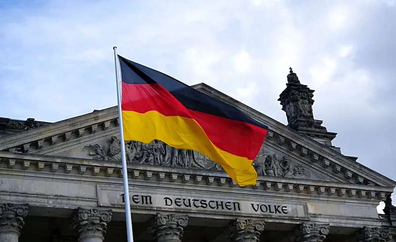 Deutsche Flagge wedelt im Wind vor einem deutschen Staatsgebäude